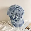 Dettaglio della cuffia in denim blu chiaro lavato con bordi sfilacciati ed effetto strappato - M (56-58cm) / Azzurro