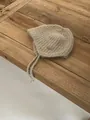 Close-up of knit baby bonnet in light brown mohair with Coco Park metal logo tag - M (56-58cm) / Khaki