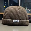 Detail of dark brown ribbed knit docker hat with FJMS woven label and folded brim - M / Coffee