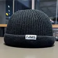 Detail of black ribbed knit miki hat with FJMS woven label and thick texture - M / Black