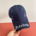 Dettaglio dei bordi sfrangiati e del ricamo Freedom sul cappello di cotone blu - M(56-58cm) / Blu navy