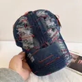 Détail d'une casquette en jean bleu délavé avec des coutures rouges contrastées - M / Bleu Clair (Coutures Rouges)