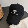 Detalle del bordado blanco Lucky Girl y el patrón de corazón en una gorra de algodón negro - M (56-58cm) / Negro