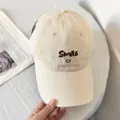 Close-up of beige baseball cap with brown Smile embroidery and reinforced stitched brim - M (56-58cm) / Beige