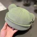 Detail of pea green beanie with cute cat ears and a metal ring accessory on the side - M (56-58cm) / Bean Green