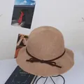 Women's sun protection straw bucket hat with bow accent and elegant wavy brim - M / Khaki