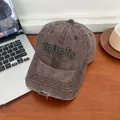 Detail einer Vintage-Baseballkappe mit grüner TRUSTS-Stickerei auf einem Holztisch - M (56-58cm) / Kaffeebraun