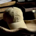 Close-up of vintage khaki washed cotton baseball cap with silver metal H logo detail - M (56-58cm) / Khaki Yellow