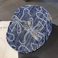 Nahaufnahme der blauen Denim-Baskenmütze mit weißer Stickerei und Goldpailletten - M (56-58cm) / Dunkelblau