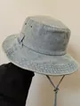 Close-up of light blue washed denim bucket hat with metal eyelets and adjustable chin cord - M (56-58cm) / Light Blue
