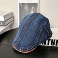 Detail of denim flat cap featuring orange stitching and adjustable side buckle on wood - M (56-58cm) / Dark Blue