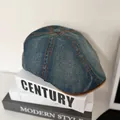 Detailed top view of retro denim ivy cap with orange stitching on decorative books - M / Vintage Blue