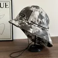 Black and white tie-dye bucket hat with adjustable drawstring on a minimalist stand - M (56-58cm) / Black & White