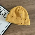 Dettaglio del berretto in maglia zenzero con spille e anelli su fondo in legno - M (56-58cm) / Giallo