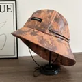 Detailed view of tie-dye bucket hat in brown and orange with an adjustable black chin strap - M (56-58cm) / Orange