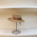 Close-up of the woven texture and brown ribbon detail with metal logo on a boater hat - M (56-58cm) / Khaki