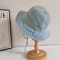 Detail of light blue washed denim bucket hat with wide brim and adjustable wind strap - M (56-58cm) / Light Blue