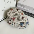 Dettaglio del motivo jacquard a farfalla colorata sul tessuto della coppola vintage - M / Beige