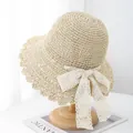 Close-up of fine hand-woven straw hat with delicate scalloped edges and white lace bow - M (56-58cm) / Beige