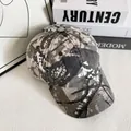 Détail d'une casquette de baseball camouflage avec motif tacheté gris et beige sur fond blanc - M (56-58cm) / Camouflage de Branches