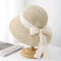 Schicker beige Strohhut mit breiter Spitzen-Schleife auf Holzständer für den Strand - M / Beige