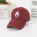 Dettaglio di un berretto da baseball bordeaux vintage con ricamo bianco su sfondo bianco - M (56-58cm) / Borgogna