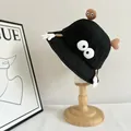 Detail of black cotton bucket hat featuring funny cartoon eyes and glove decorations - M / Black