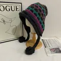Detail of Fair Isle knit pattern and fluffy pom-poms on a vintage ear protection hat - M (56-58cm) / Black