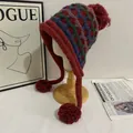 Detailed knit of winter earflap hat with Fair Isle patterns and red pom poms - M (56-58cm) / Burgundy