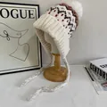 Detail of Fair Isle knit trapper hat with pom-poms and warm ear flaps in cream white - M (56-58cm) / White