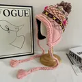 Dettaglio del cappello in maglia rosa con motivi geometrici colorati e nappe - M (56-58cm) / Rosa