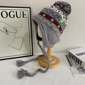 Dettaglio del cappello in maglia grigio con pompon colorati e paraorecchie etnici - M (56-58cm) / Grigio