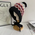 Macro view of Fair Isle pattern knit hat with soft pompom and fleece lining detail - M / Black
