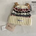 Detailed close-up of Fair Isle knit hat with reindeer antlers and brand tags - M (56-58cm) / White