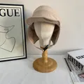 Dettaglio del cappello invernale beige con paraorecchie antivento e cinturino regolabile - M(56-58cm) / Bianco avorio