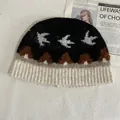 Detaillierte Stricktextur der Beanie mit Schwalben-Jacquard und warmem Ohrenschutz - M (56-58cm) / Schwarz