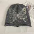 Detail of dark grey mohair beanie featuring a cream butterfly jacquard and fuzzy texture - M (56-58cm) / Gray