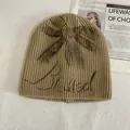 Khaki rib-knit beanie featuring bow detail and Illegal graffiti print for women - M (56-58cm) / Khaki
