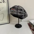 Detail view of the vintage plaid beret featuring embroidery and black leather trim - M (56-58cm) / Black