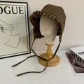 Detailed view of dark brown leather winter hat with leopard print faux fur lining and earflaps - M(56-58cm) / Coffee
