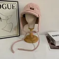 Dettaglio del cappello da aviatore rosa in lana d'agnello con etichetta in pelle su supporto - M / Rosa