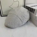 Dettaglio del berretto grigio a spina di pesce con strass scintillanti sul tessuto - M / Grigio/Bianco