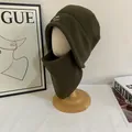 Vista detallada del gorro de forro polar verde oscuro con bordado en soporte de madera - Verde Militar