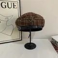 Detail van geruite baret met zilveren ankertje en zwarte glanzende leren band - M (56-58cm) / koffiekleur