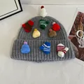 Détail d'un bonnet gris en maille avec décorations colorées de mini gants et chapeaux - Gris clair