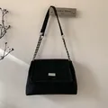 Detail of black suede shoulder bag with silver chain strap and rectangular metal hardware - Black