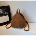 Nahaufnahme des dunkelbraunen Kunstleder-Rucksacks mit matter Textur und silbernem Reißverschluss - Basisstil / Braun
