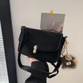 Black matte shoulder bag with golden peanut clasp and grey plush monster charm - With Pendant / Black