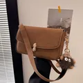 Brown leather square crossbody bag with peanut-shaped lock and plush monster charm - With Pendant / Brown