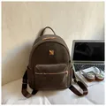Detail view of premium brown suede backpack with elegant gold zippers and hardware - Brown